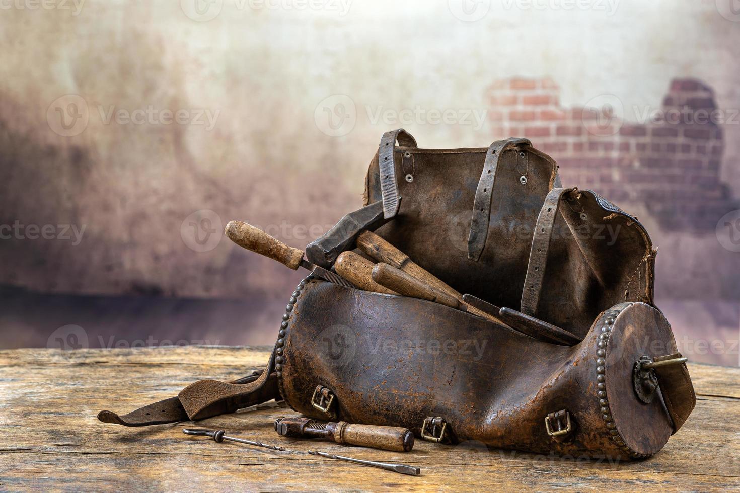 ensemble d'outils dans le vieux sac en cuir sur le plancher en bois d'omd photo