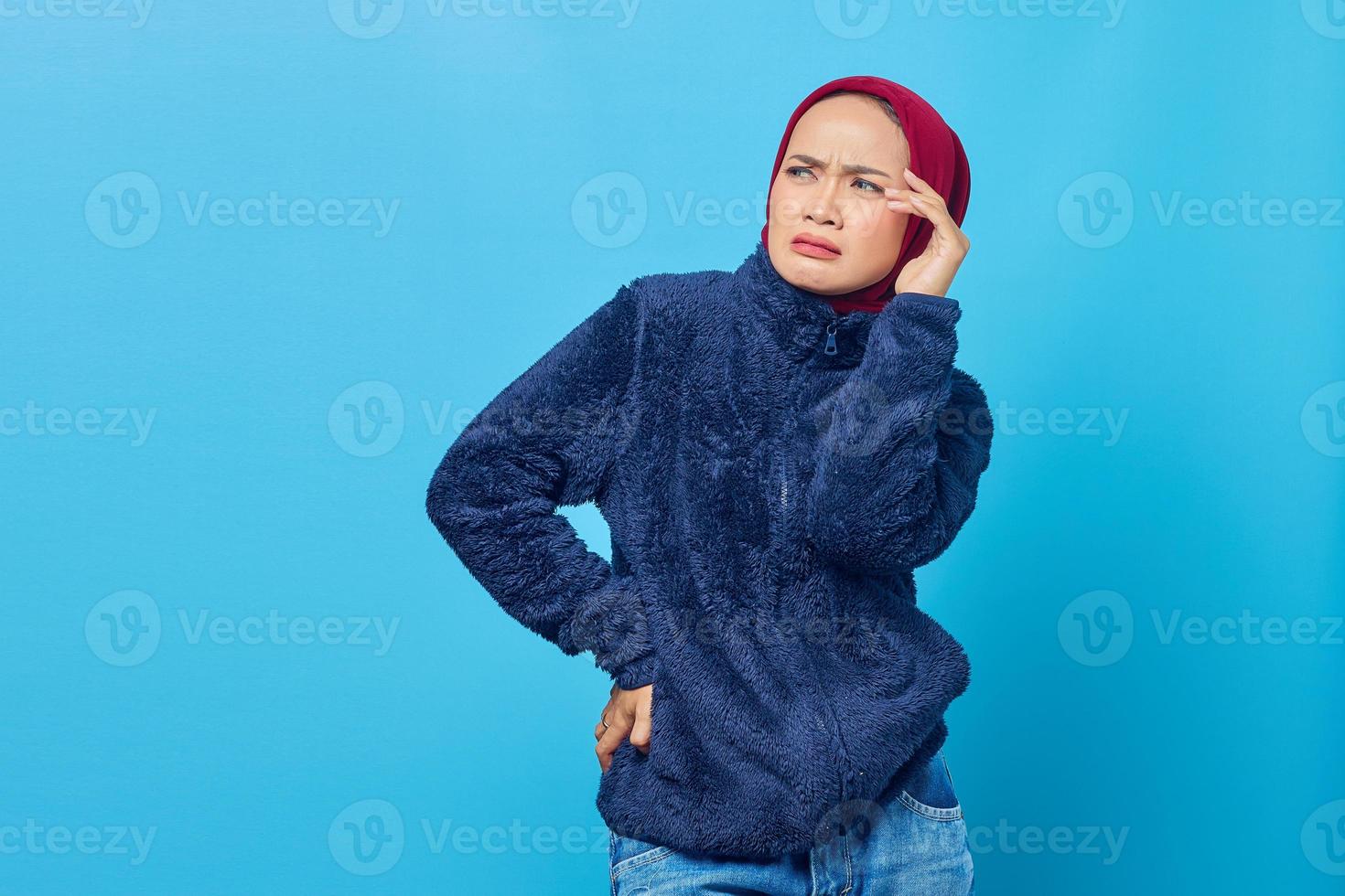 Portrait d'une jeune femme asiatique ayant des vertiges et des maux de tête sur fond bleu photo