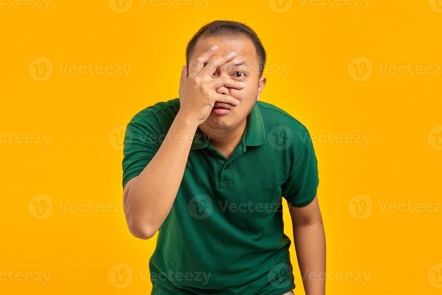 Portrait d'un jeune homme asiatique surpris avec une paume cachée visible à propos de son erreur sur fond jaune photo