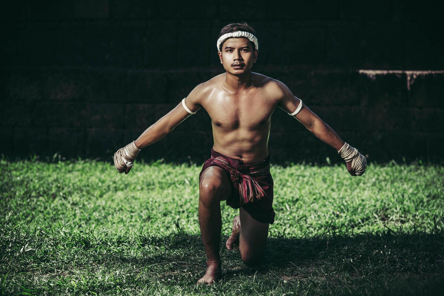 un boxeur a attaché une corde dans sa main et a effectué un combat, les arts martiaux du muay thai. photo