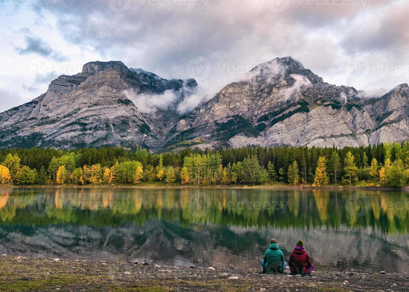 Voyageur en couple se reposant sur la côte dans un étang de coin au pays de Kananaskis photo