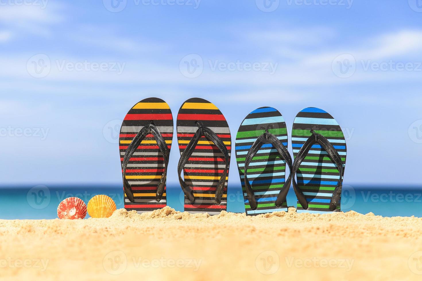 tongs sur la plage de sable photo