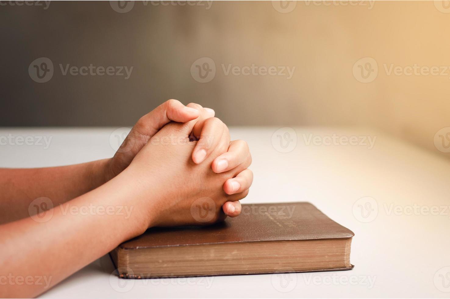 prière de crise de la vie chrétienne à dieu. l'homme prie pour que Dieu bénisse et souhaite avoir une vie meilleure. mains d'homme priant dieu avec la bible. croire en la bonté. main dans la main en prière sur une table en bois. photo