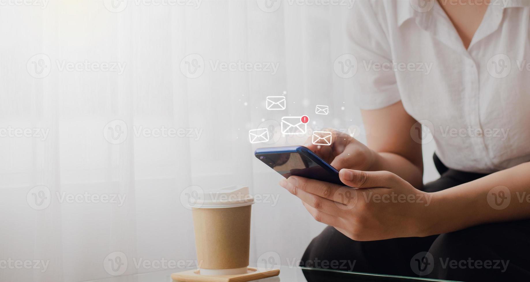 jeune femme tenant un téléphone intelligent envoyant un message électronique et vérifiant les e-mails en ligne sur le Web avec le concept technologique avec l'icône de la boîte. photo