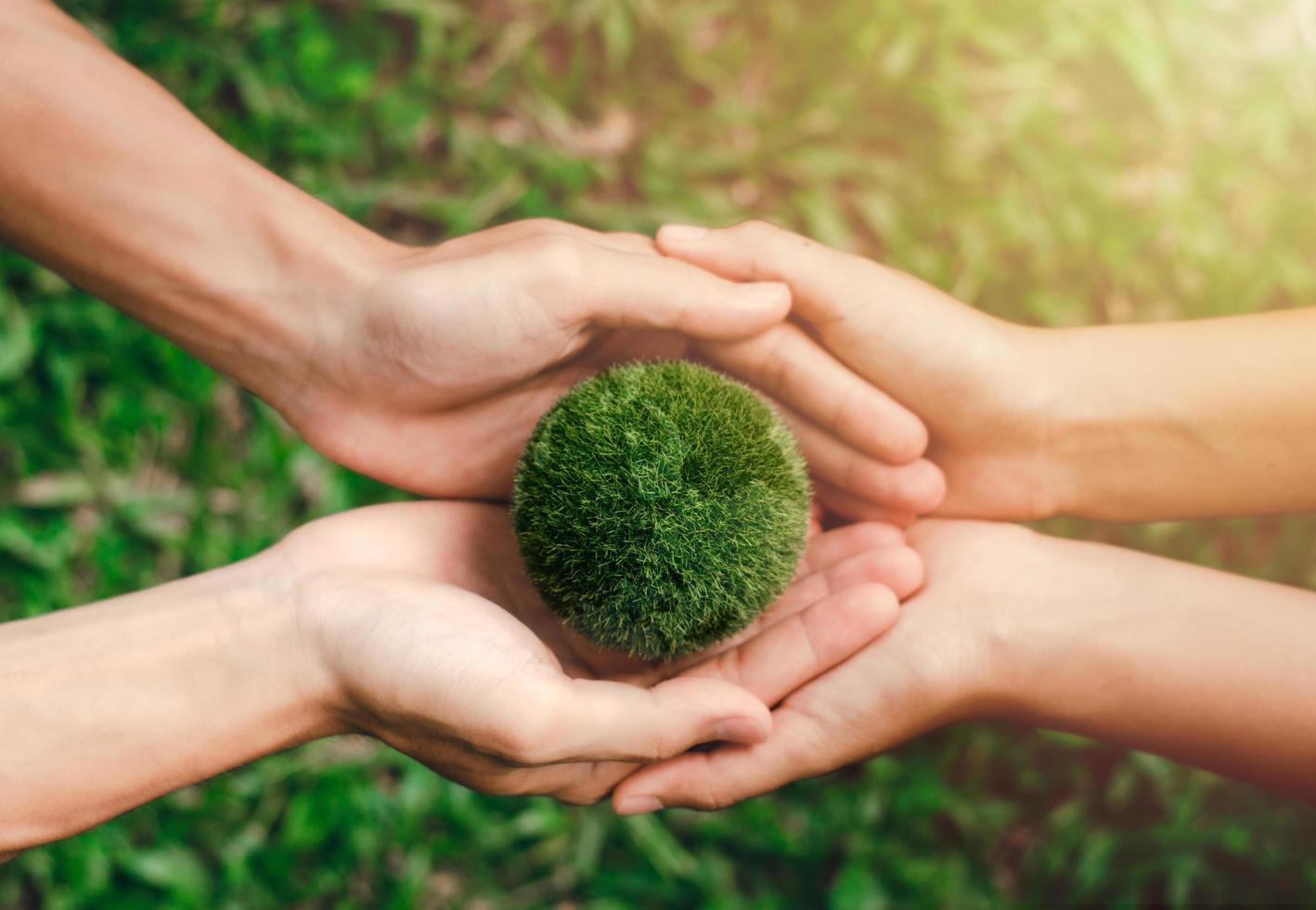 travailler ensemble pour protéger l'environnement jour de la terre deux mains tiennent ensemble les deux mondes verts. l'environnement et réduire le réchauffement climatique aident le monde dans le concept de durabilité écologique photo