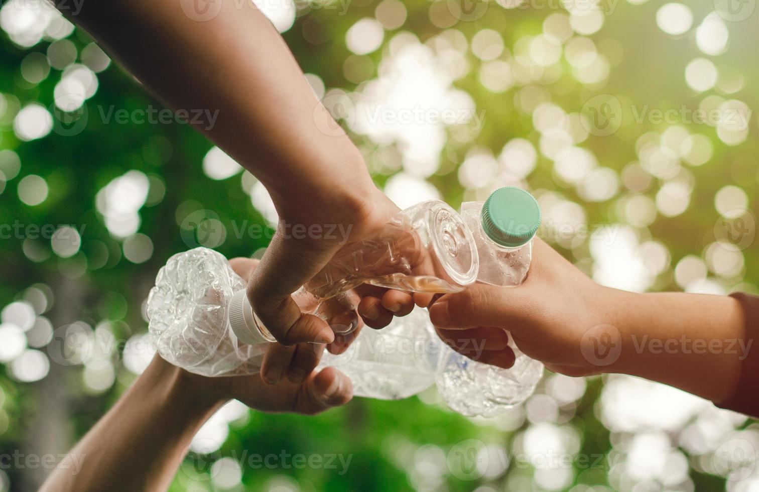 éliminer les déchets pour conserver un monde meilleur avec un bon environnement et une atmosphère naturelle main dans la main en équipe, unité, tenant ensemble des bouteilles en plastique. réduire le réchauffement climatique sauver le monde photo