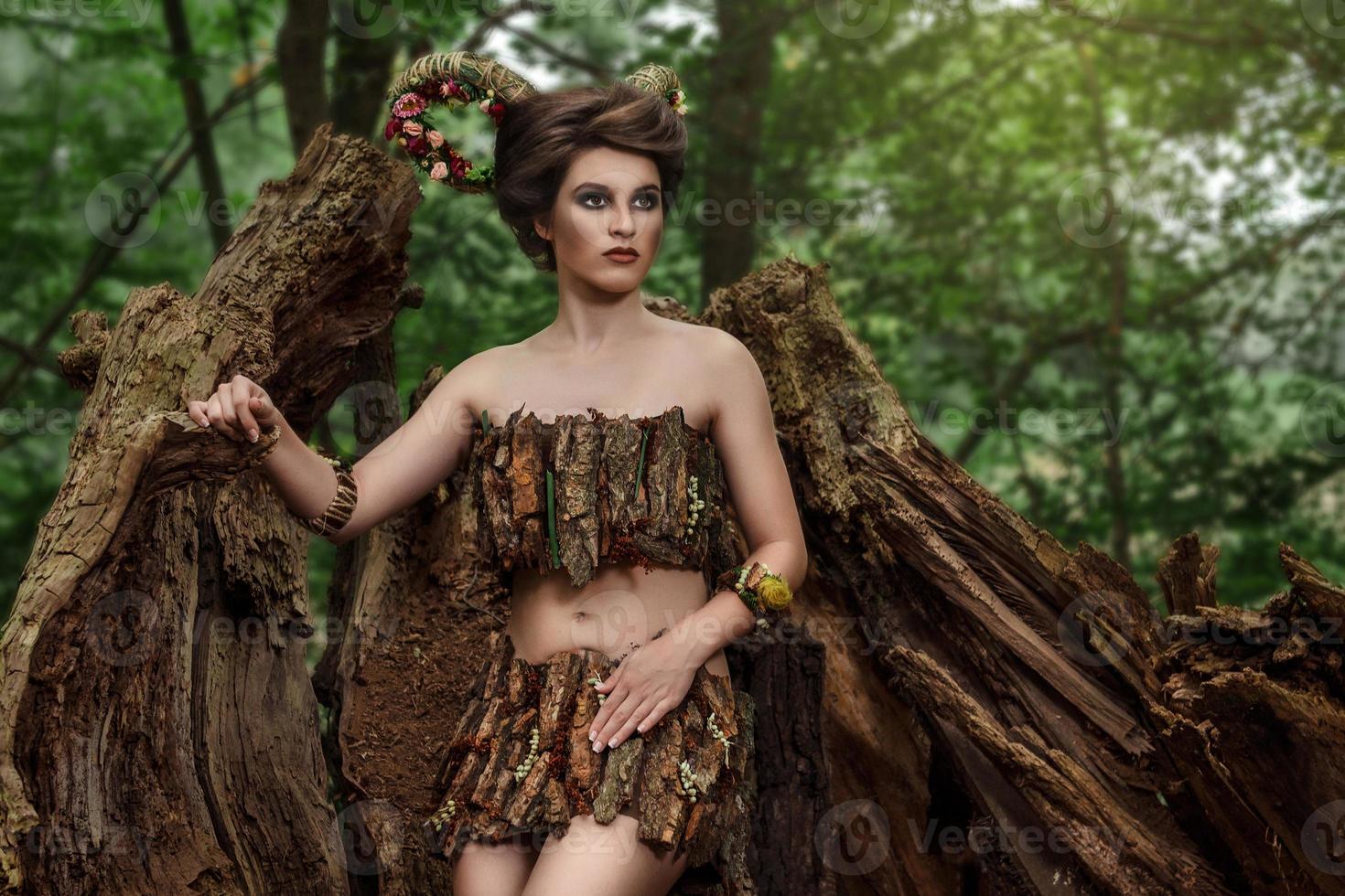 fille aux cornes tressées dans une robe en écorce sur une forêt photo