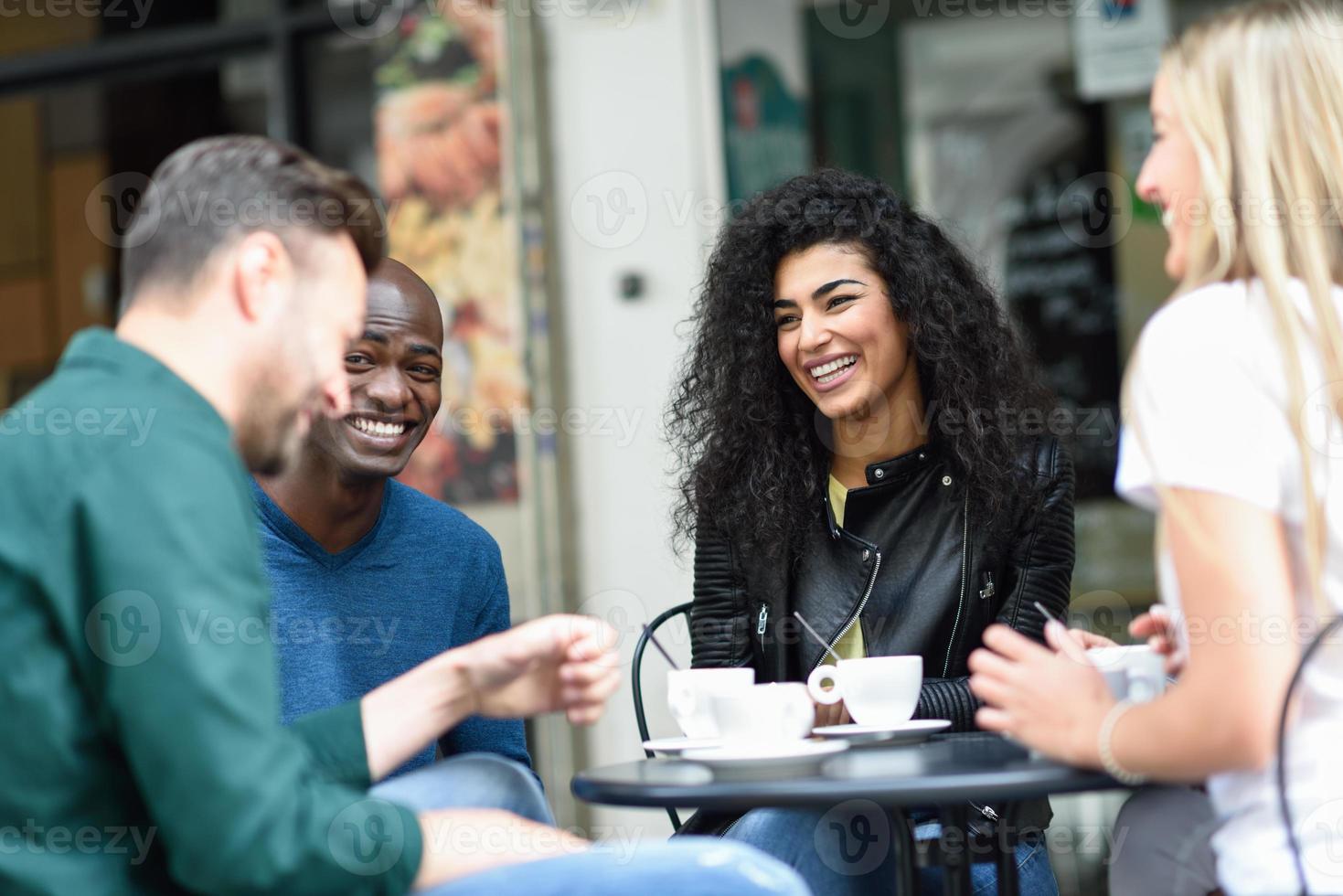 groupe multiracial de quatre amis prenant un café ensemble photo