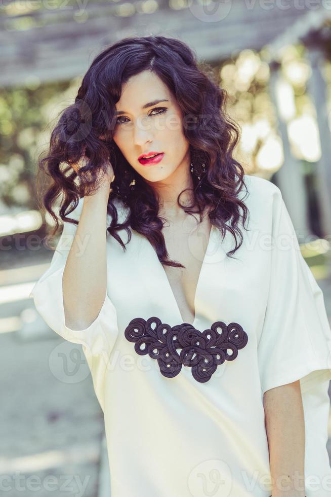 femme, mannequin, vêtue d'une robe blanche aux cheveux bouclés photo