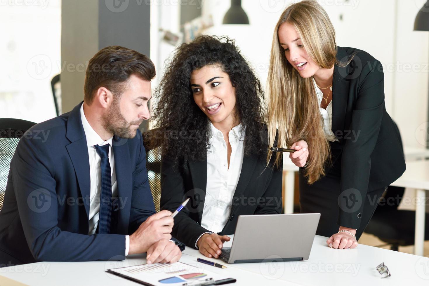 groupe multiethnique de trois hommes d'affaires se réunissant dans un bureau moderne. photo