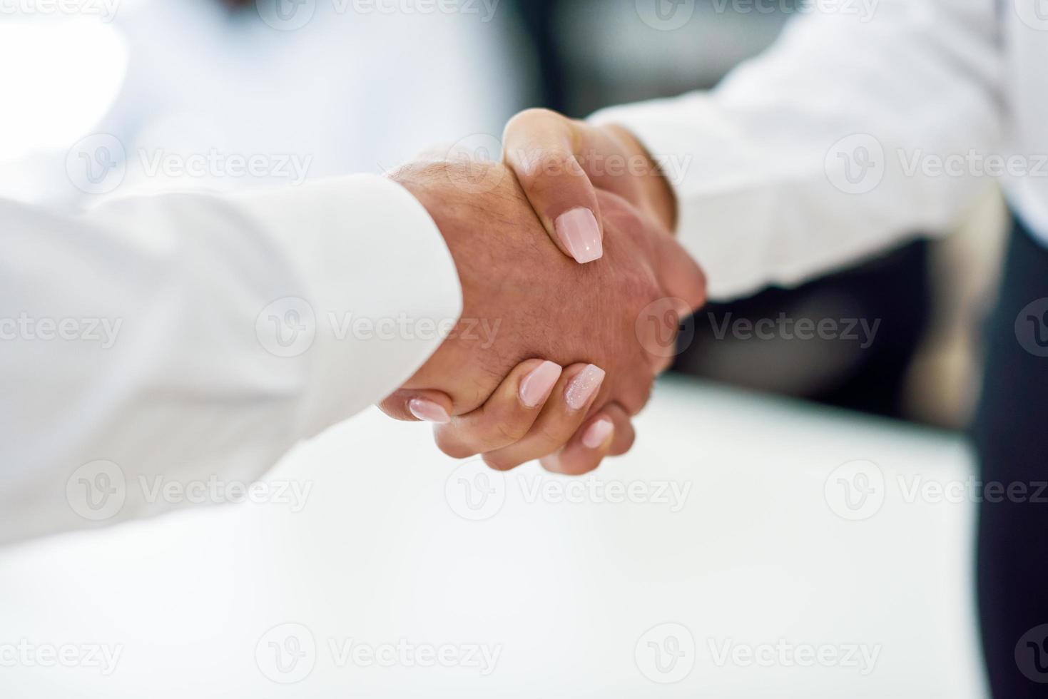 homme d'affaires caucasien serrant la main d'une femme d'affaires dans un bureau photo