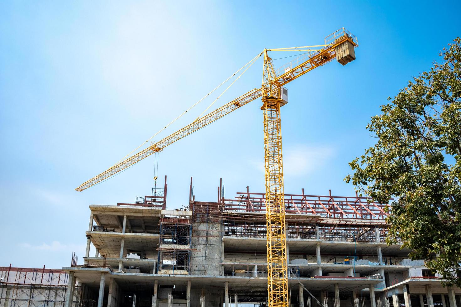 le site est en construction, un grand bâtiment avec une grue jaune photo