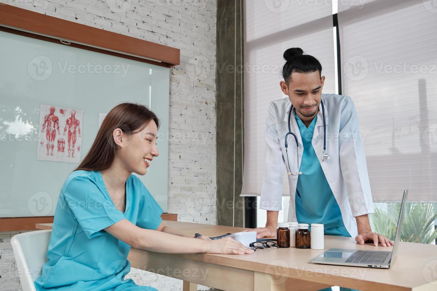 partenaires de l'équipe de soins de santé. deux jeunes médecins asiatiques en uniforme sont des collègues discutant des médicaments dans le bureau de la clinique de l'hôpital. les spécialistes sont des experts et des professionnels. photo