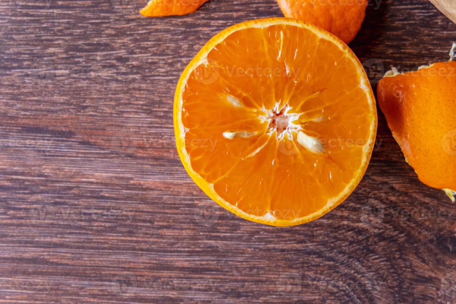 fruit orange frais et fruit orange coupé en deux sur une table en bois photo