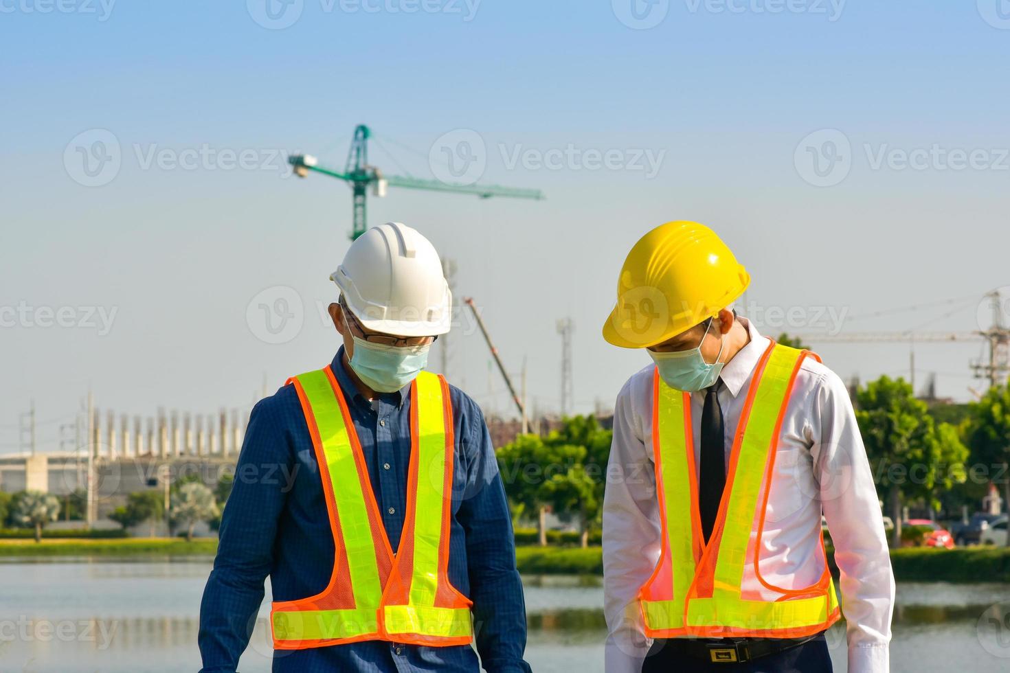 les ouvriers du bâtiment de l'équipe d'ingénieurs planifient un projet de construction sur le site en plein air photo