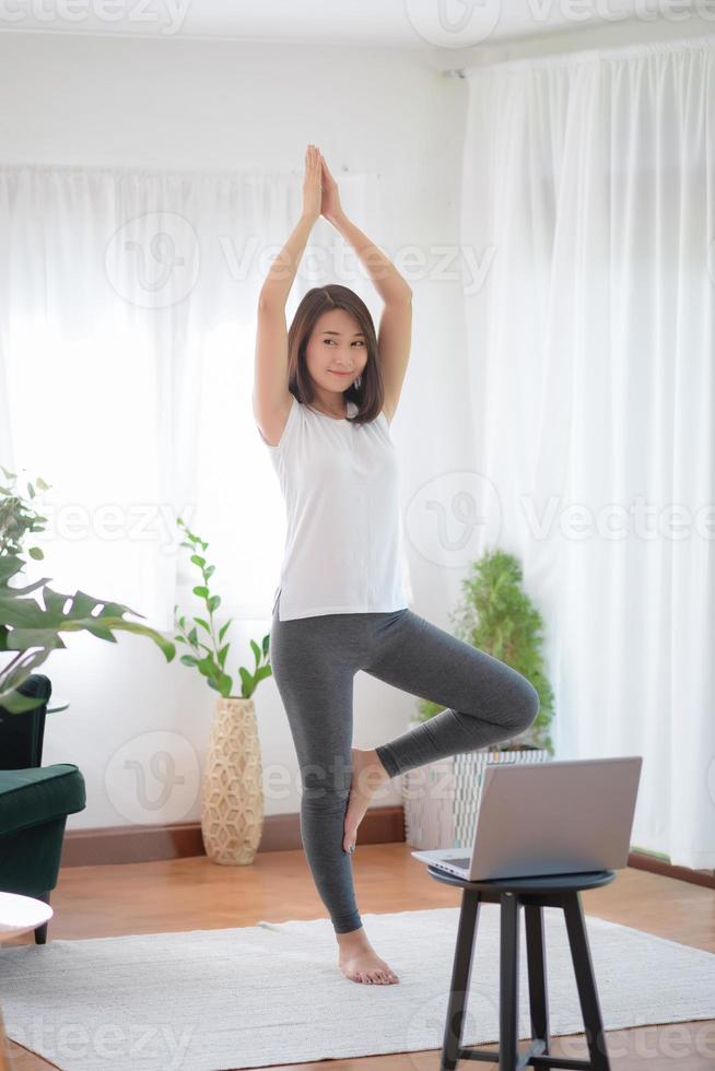 belle femme asiatique restant en forme en faisant de l'exercice à la maison pour un mode de vie tendance sain photo