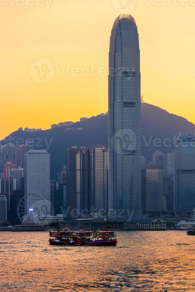 Bateau de touristes de Hong Kong pour le service touristique dans le port de Victoria avec vue sur la ville en arrière-plan au coucher du soleil vue du côté de Kowloon à Hong Kong photo