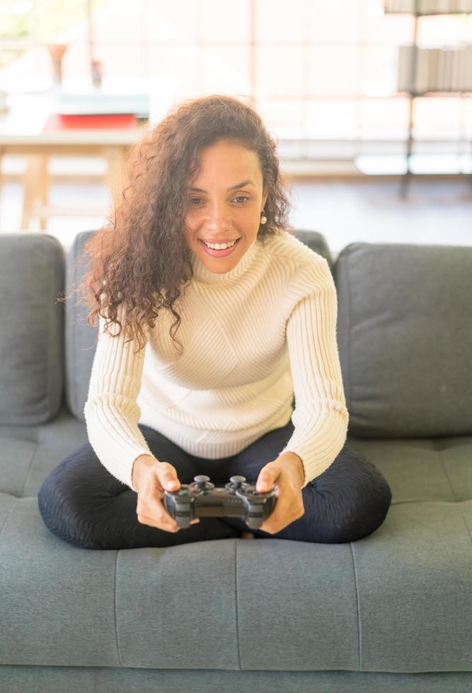 femme laitine jouant à des jeux vidéo avec les mains tenant le joystick photo