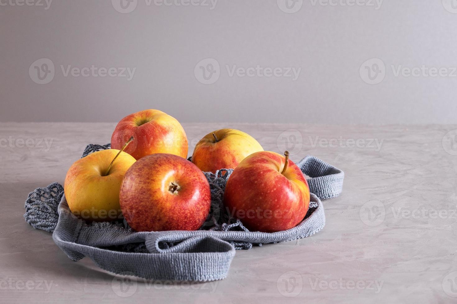 belles pommes fraîches et mûres dans un sac en filet écologique photo