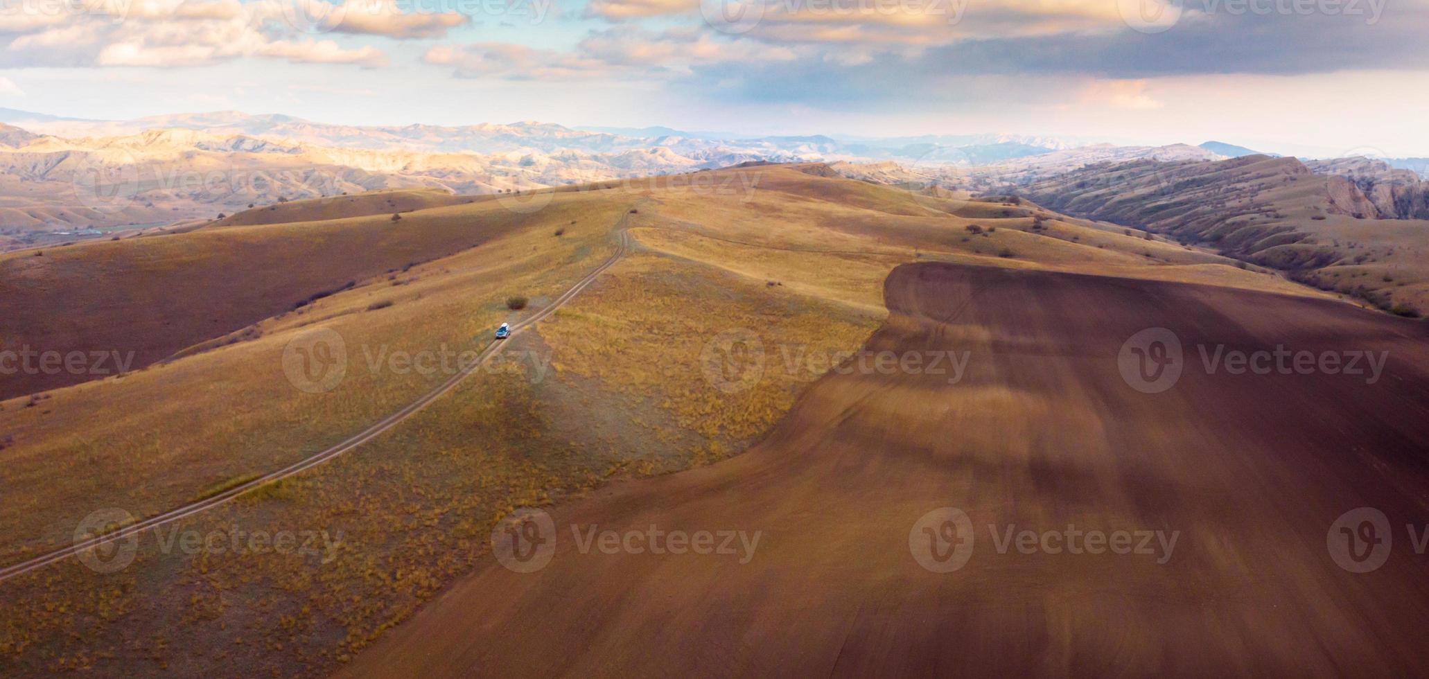 Vue panoramique aérienne du paysage de la zone protégée du parc national de Vashlovani avec jeep sur la route passig au premier plan photo