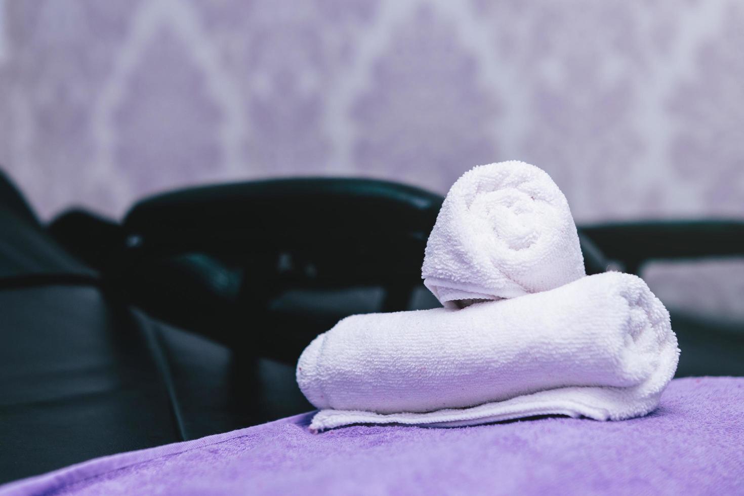 des serviettes de spa turquoise empilent sur des fauteuils avec des lavabos dans un salon de coiffure. photo