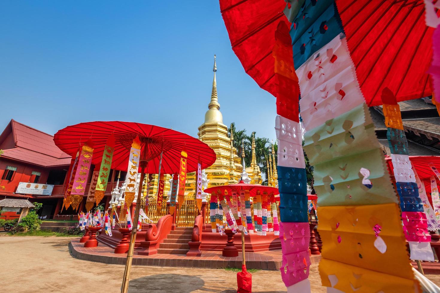 drapeaux de prière tung accrocher avec parapluie ou drapeau traditionnel du nord accroché à la pagode de sable dans le temple phan tao pour le festival de songkran est célébré le jour de l'an traditionnel à chiang mai, thaïlande photo