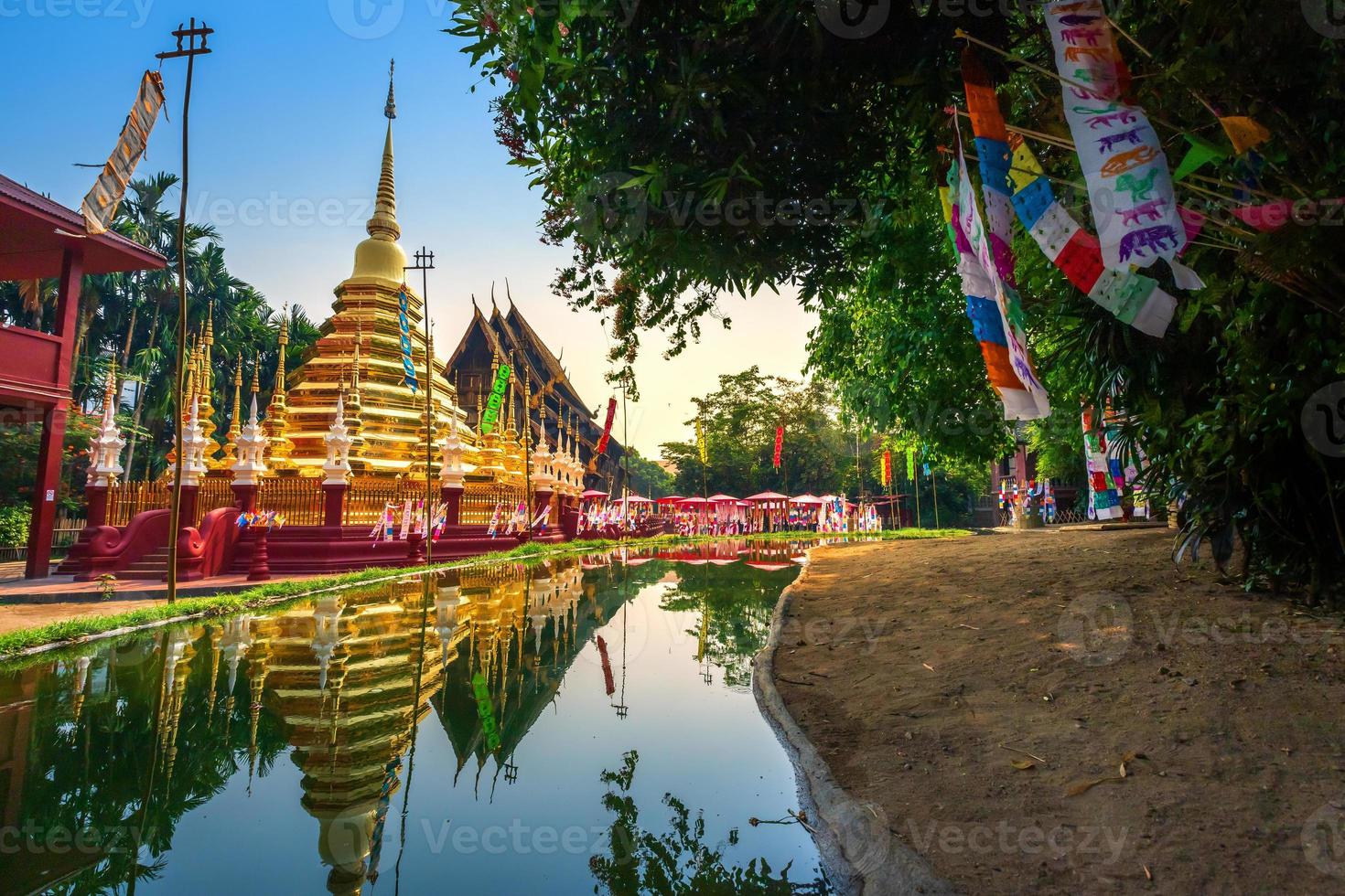 drapeaux de prière tung accrocher avec parapluie ou drapeau traditionnel du nord accroché à la pagode de sable dans le temple phan tao pour le festival de songkran est célébré le jour de l'an traditionnel à chiang mai, thaïlande photo