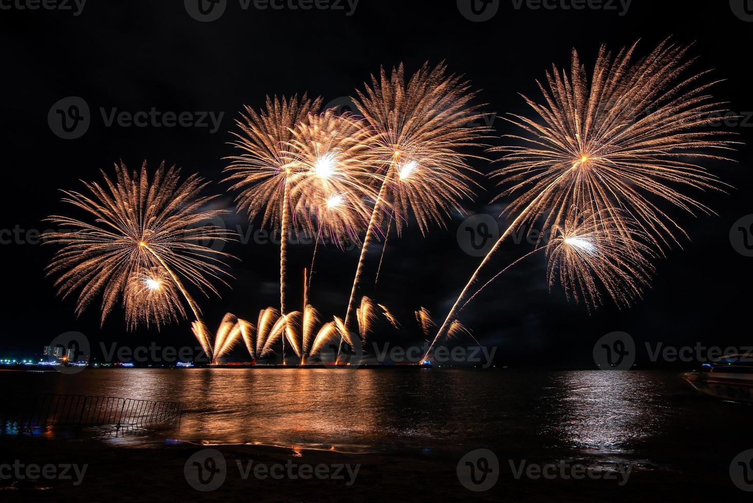 incroyable beau feu d'artifice coloré le soir de la célébration, montrant sur la plage de la mer avec plusieurs couleurs de réflexion sur l'eau photo