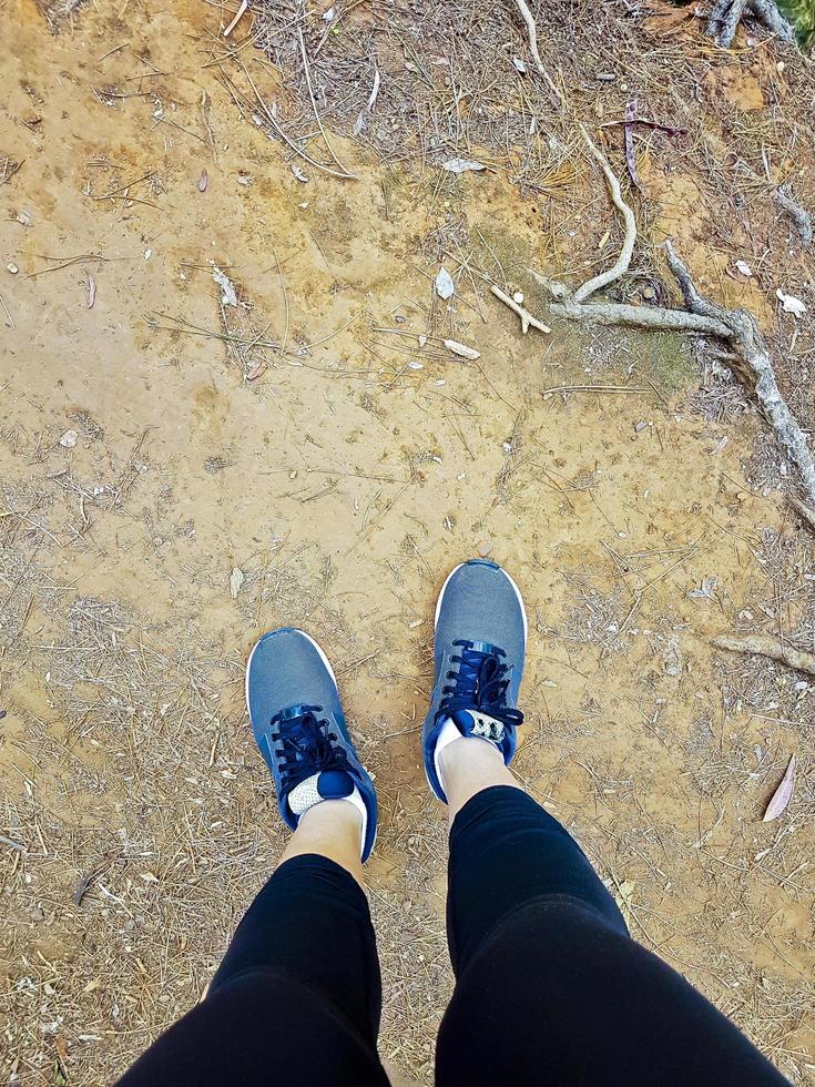 chaussures de sport d'une femme d'en haut, sol rouge africain. photo