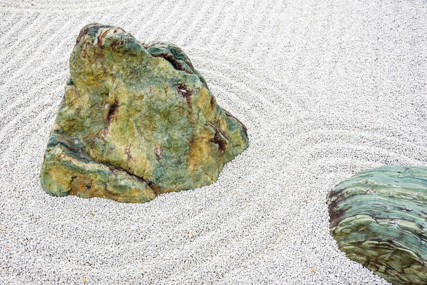 Pierre de méditation du jardin zen japonais en lignes de sable pour la relaxation, l'équilibre et l'harmonie, la spiritualité ou le bien-être à kyoto, au japon. photo