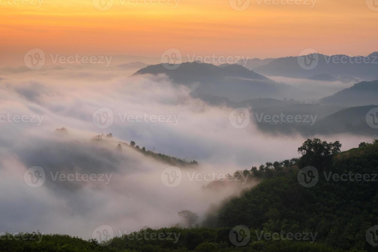 brume naturelle étonnante se déplaçant sur les montagnes naturelles au lever du soleil le matin photo