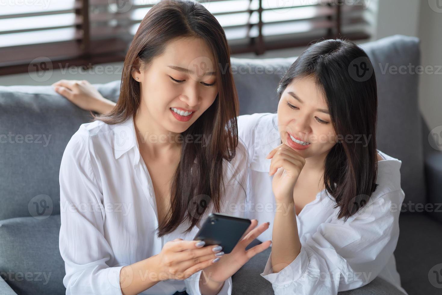 deux femmes asiatiques aiment regarder une photo sur un téléphone