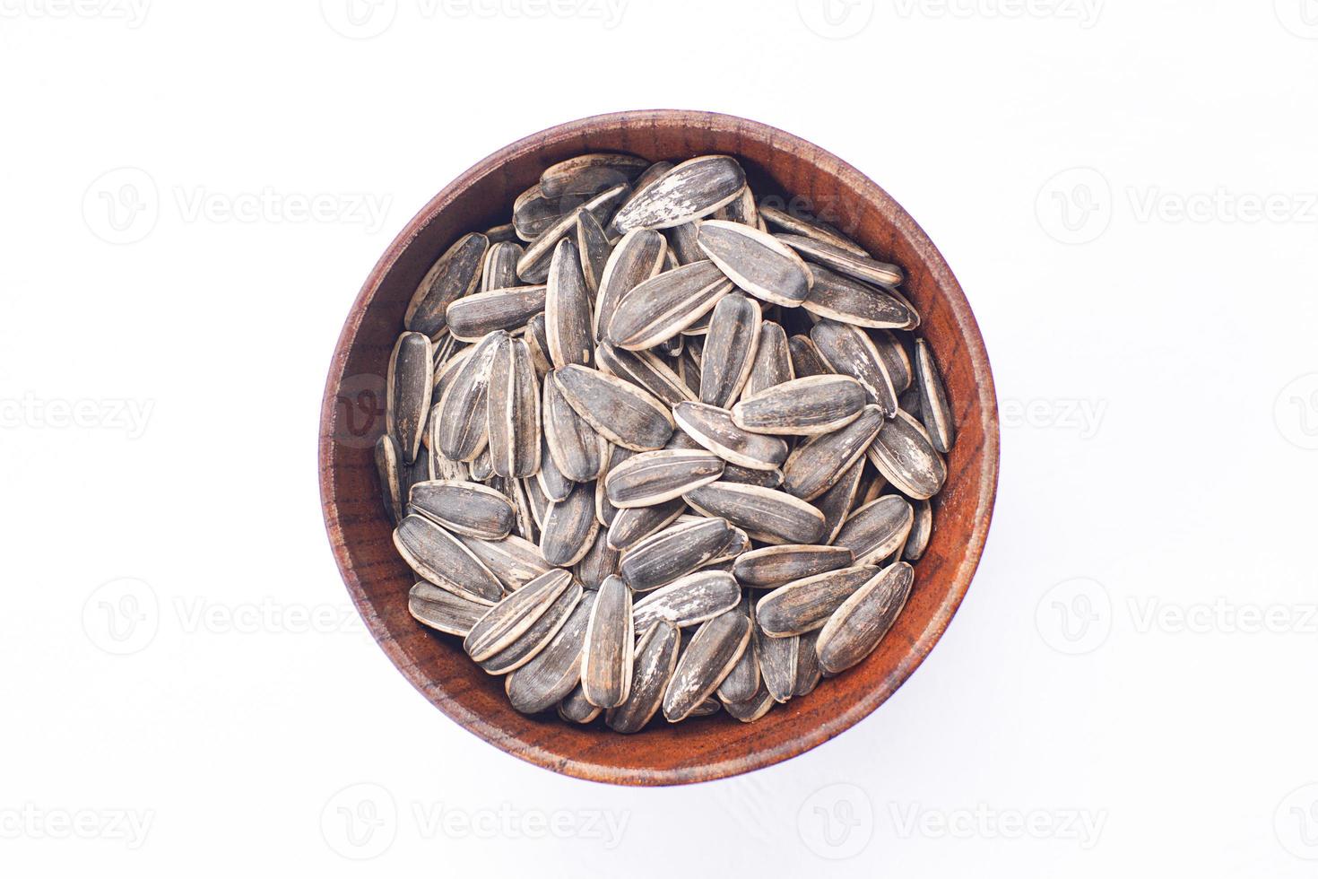 graines de tournesol dans un bol en bois sur une table blanche photo