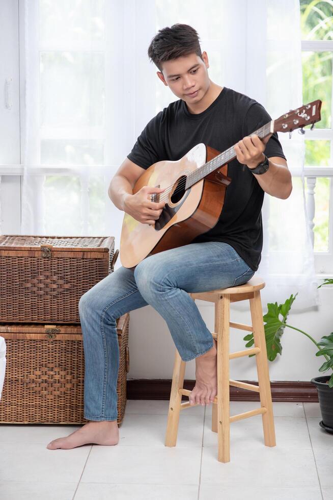 un homme assis et jouant de la guitare sur une chaise. 4890705 Photo de  stock chez Vecteezy