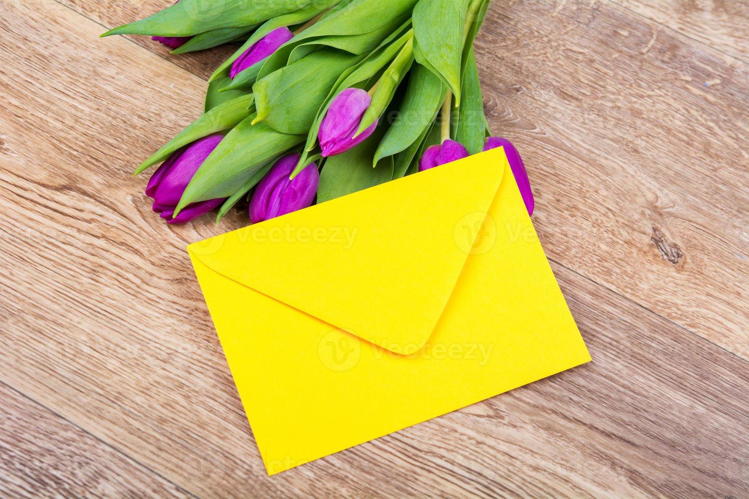 enveloppe jaune avec des tulipes sur une table photo