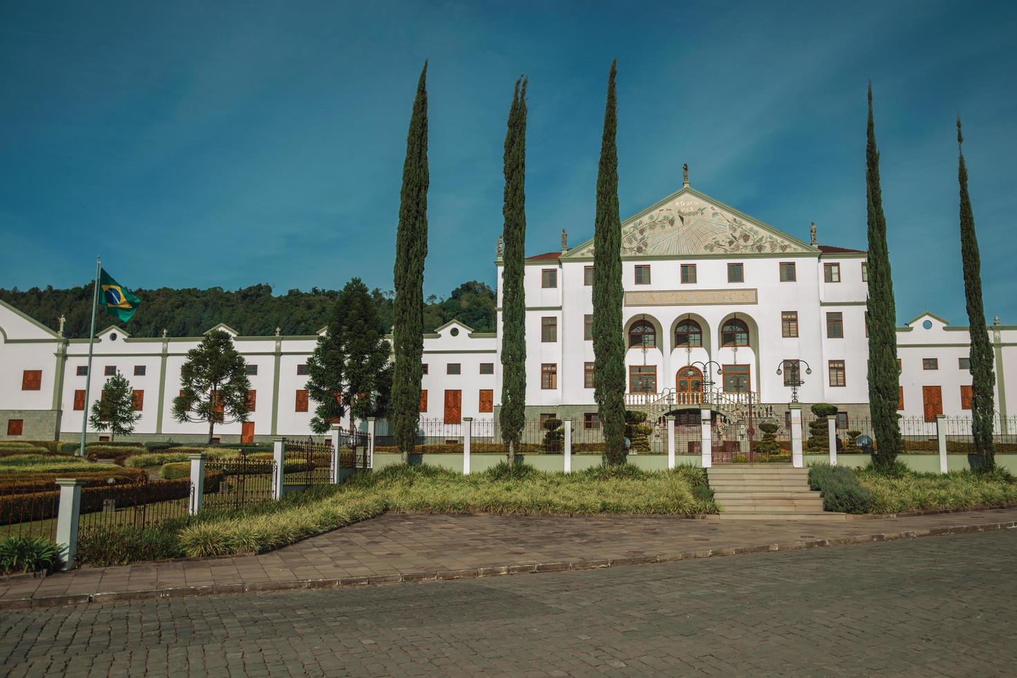 bento goncalves, brésil - 10 juillet 2019. rue avec la façade du siège social de salton winery derrière une clôture et des jardins près de bento goncalves. une ville de campagne sympathique célèbre pour sa production de vin. photo