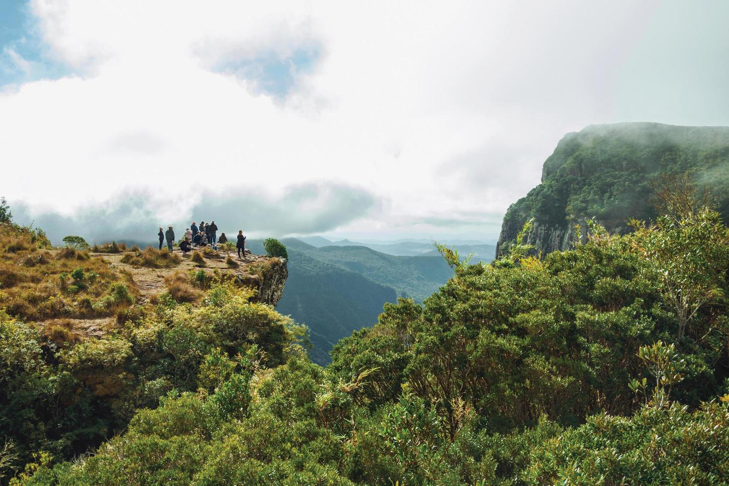 cambara do sul, brésil - 18 juillet 2019. personnes au bord d'une falaise rocheuse escarpée au canyon de fortaleza par temps nuageux près de cambara do sul. une petite ville rurale avec des attractions touristiques naturelles étonnantes. photo