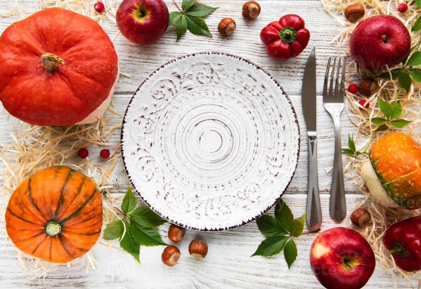 assiette vide et citrouilles d'automne colorées photo