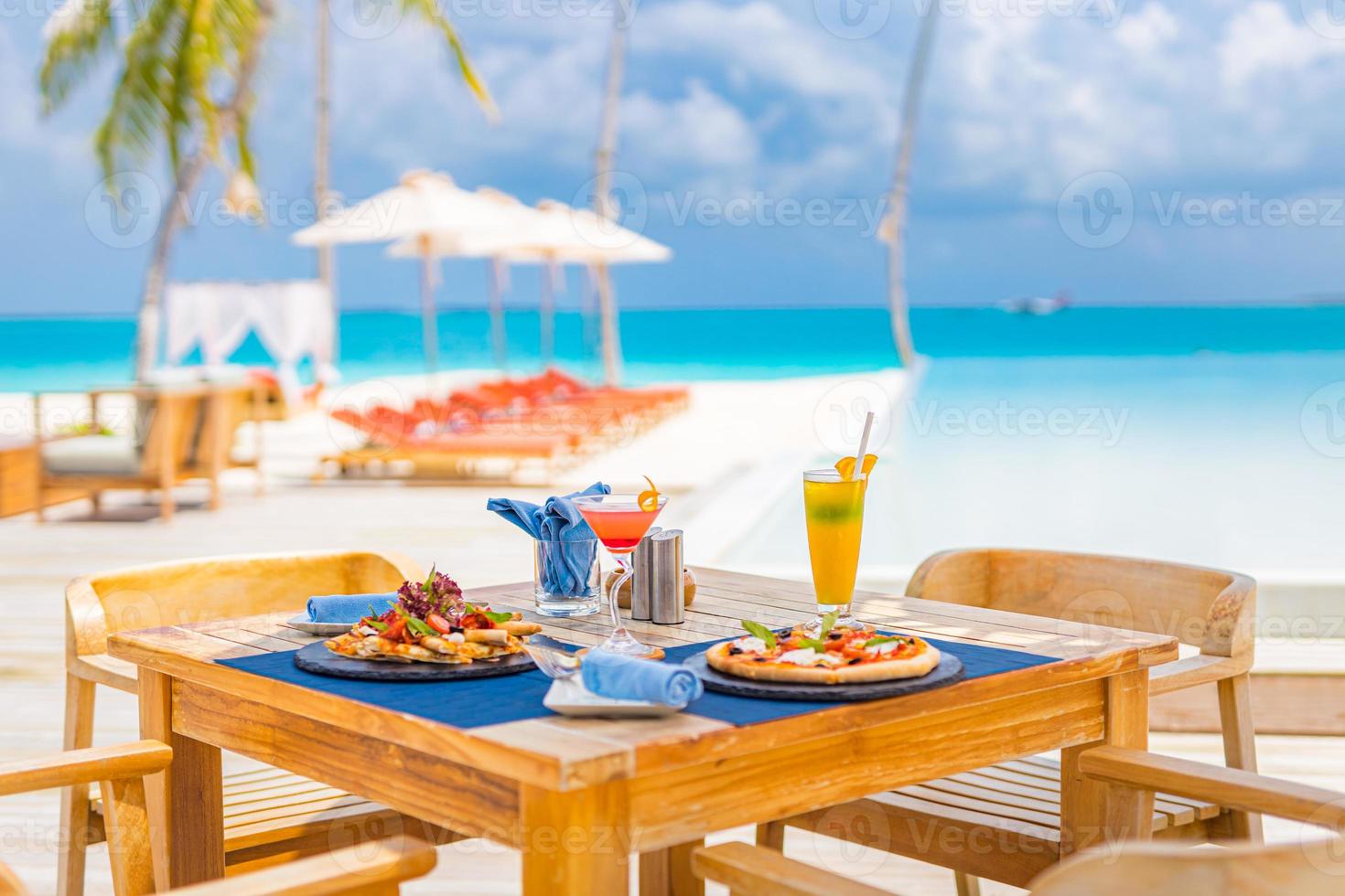 hôtel de luxe au bord de la piscine, restaurant en plein air sur la plage, l'océan et le ciel, café de l'île tropicale, tables, nourriture. vacances d'été ou vacances, voyage en famille. palmiers, piscine à débordement, cocktails, relax photo