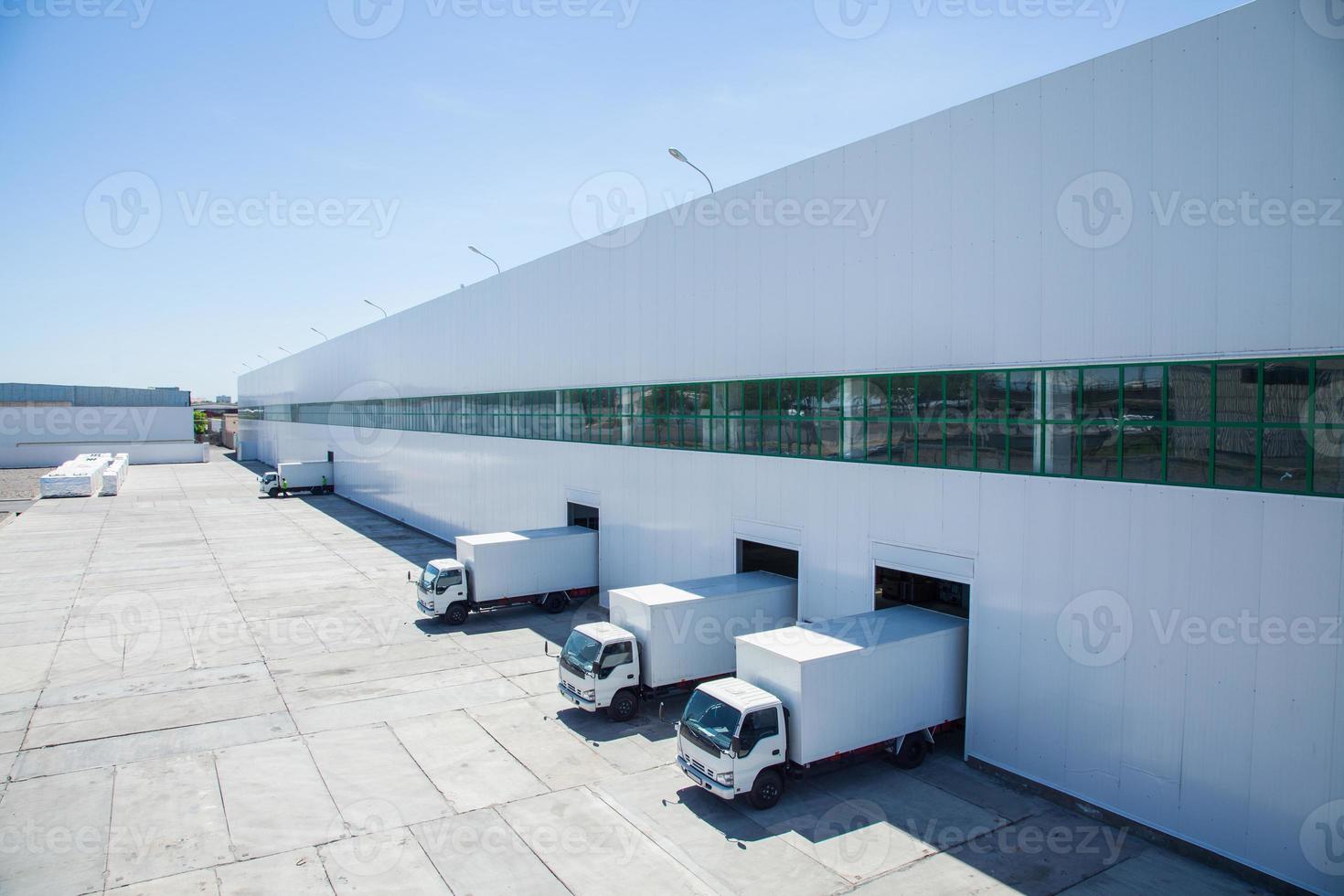 façade d'un bâtiment industriel et d'un entrepôt avec des wagons de marchandises en longueur photo