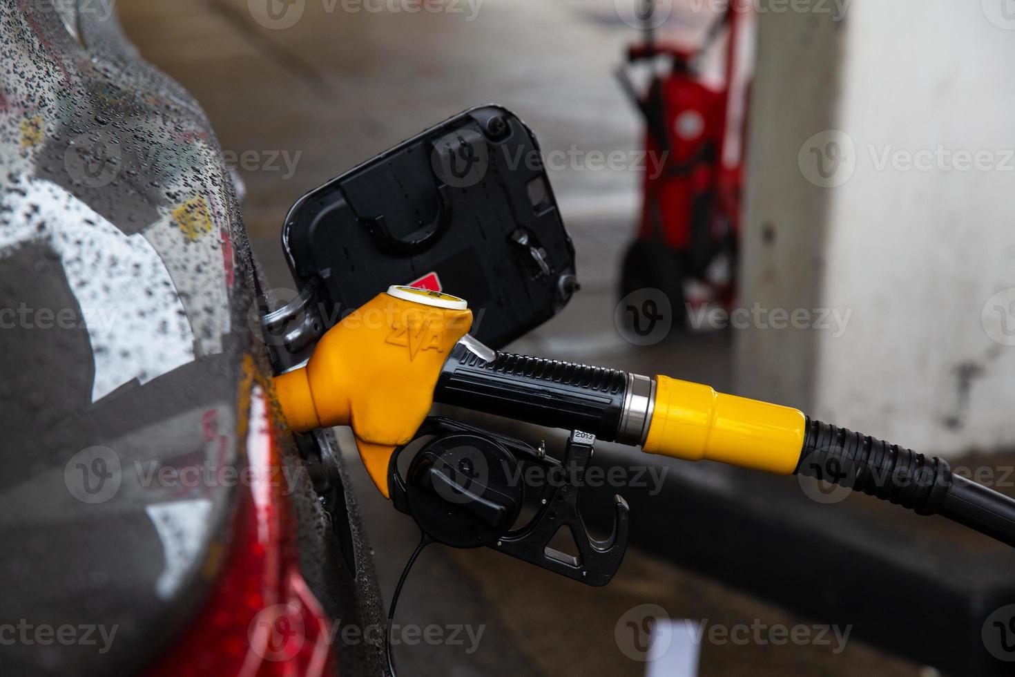 le pistolet à essence est installé dans le réservoir du véhicule, pistolet à essence jaune. photo