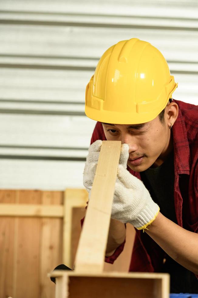 jeune homme asiatique charpentier travaille méticuleusement pour les clients c'est un jeune homme, un entrepreneur prospère et très compétent. photo