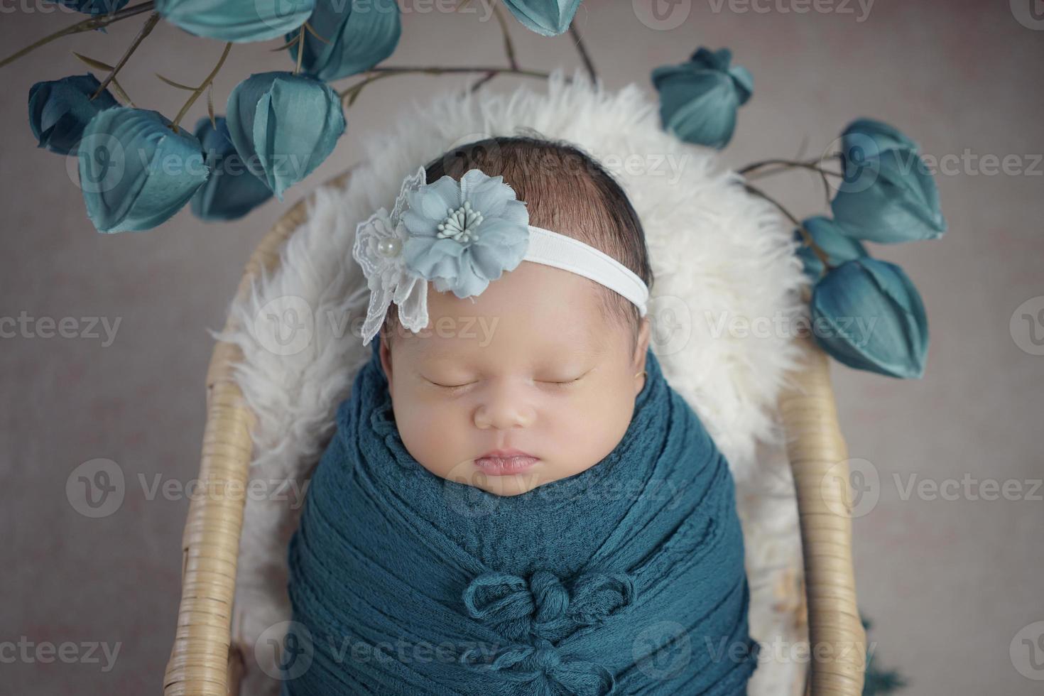 le petit bébé avec un bandage sur la tête dort sur le panier photo