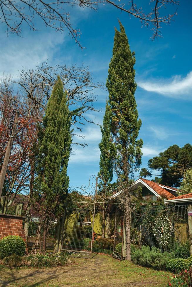 gramado, brésil - 21 juillet 2019. entrée avec jardin luxuriant et portail en fer fermé d'une maison par une journée ensoleillée à gramado. une jolie ville d'influence européenne très recherchée par les touristes. photo