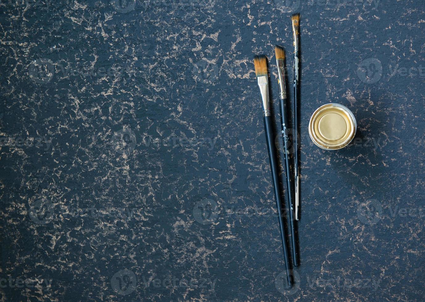 pinceau d'art et un pot sur fond bleu doré, vue de dessus photo