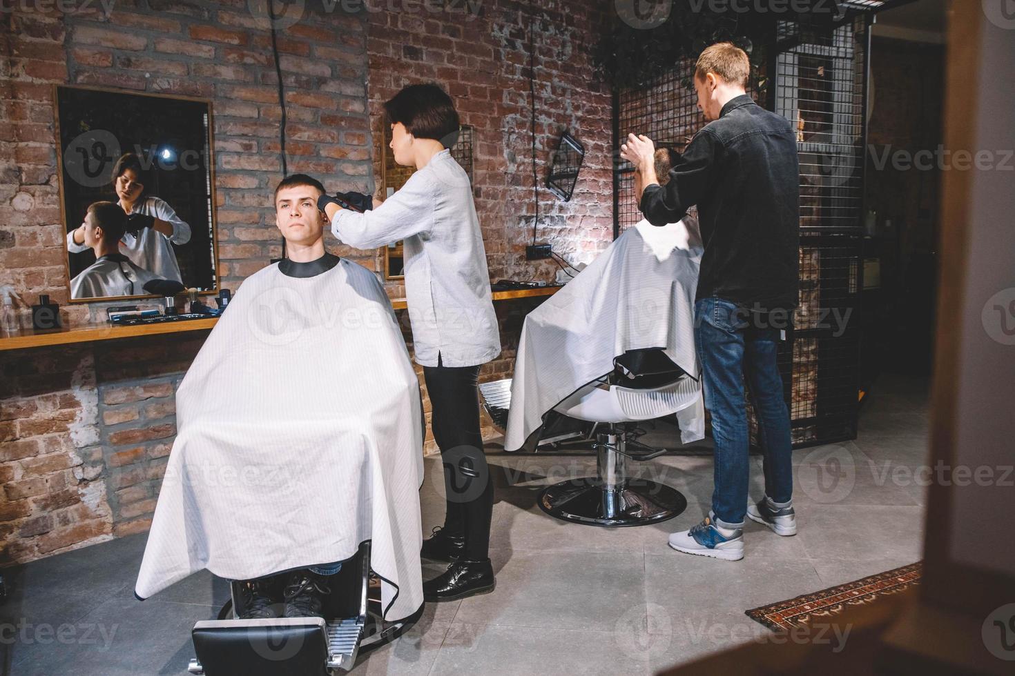 les coiffeurs coupent leurs clients dans un salon de coiffure. concept de publicité et de salon de coiffure photo