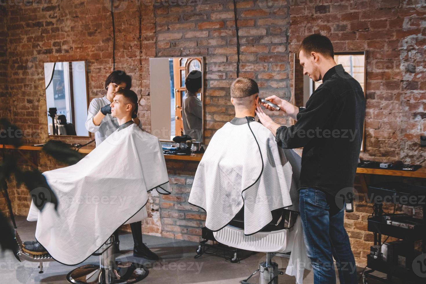 les coiffeurs coupent leurs clients dans un salon de coiffure. concept de publicité et de salon de coiffure photo