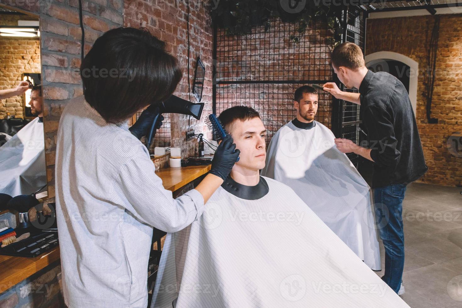 les coiffeurs coupent leurs clients dans un salon de coiffure. concept de publicité et de salon de coiffure photo