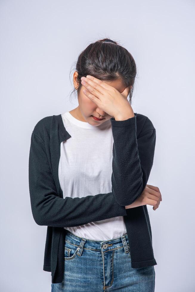 une femme malade avec un mal de tête et a mis sa main sur sa tête photo