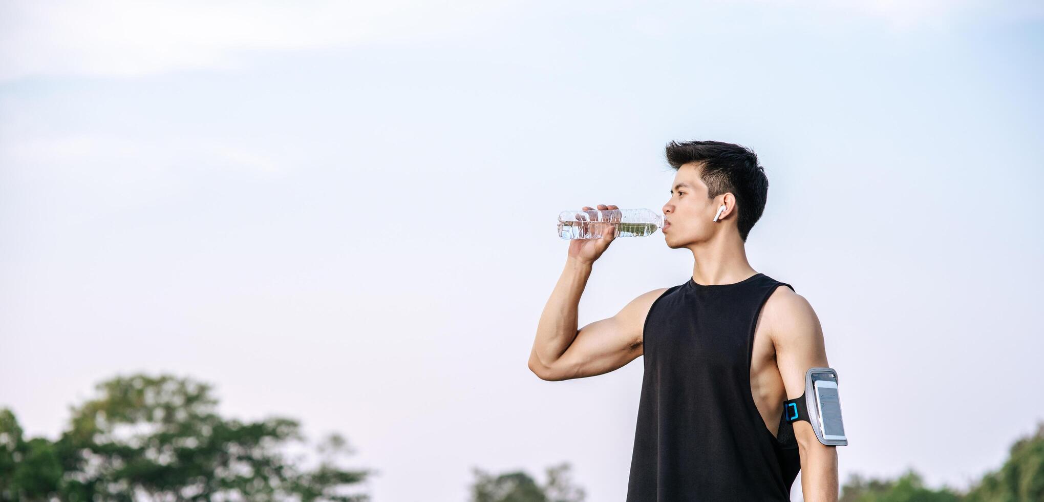 les hommes se tiennent debout pour boire de l'eau après l'exercice photo